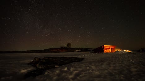 Bonfire-And-Cabin-At-Night-With-Beautiful-Stars-In-The-Night-Sky