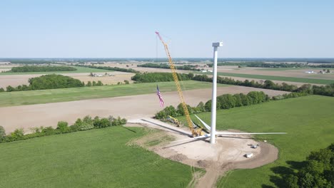 ondear la bandera de los estados unidos en el sitio de construcción de la turbina eólica, vista aérea