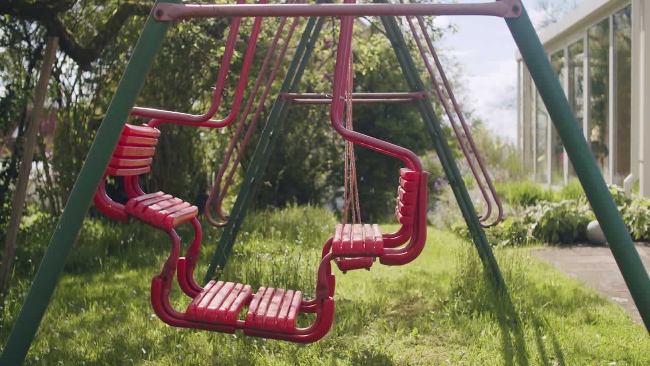 Medium wide shot of a swingset on a sunny spring day