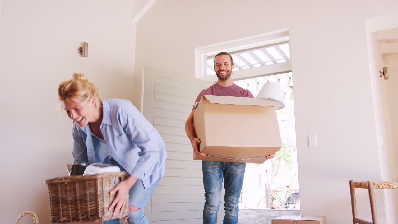 Slow Motion Shot Of Couple Carrying Boxes Into New Home On Moving Day