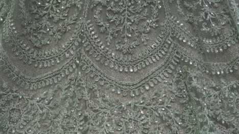 a sparkling mint green bridal gown with intricate embroidery, perfect for receptions. slow motion.