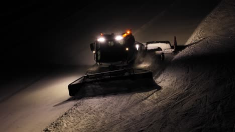 limpieza de nieve trabajando por la noche en los dolomitas, alpes italianos, con luces brillantes y un sendero claro detrás