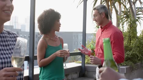 diverse business colleagues having drinks and talking to each other in the balcony at office