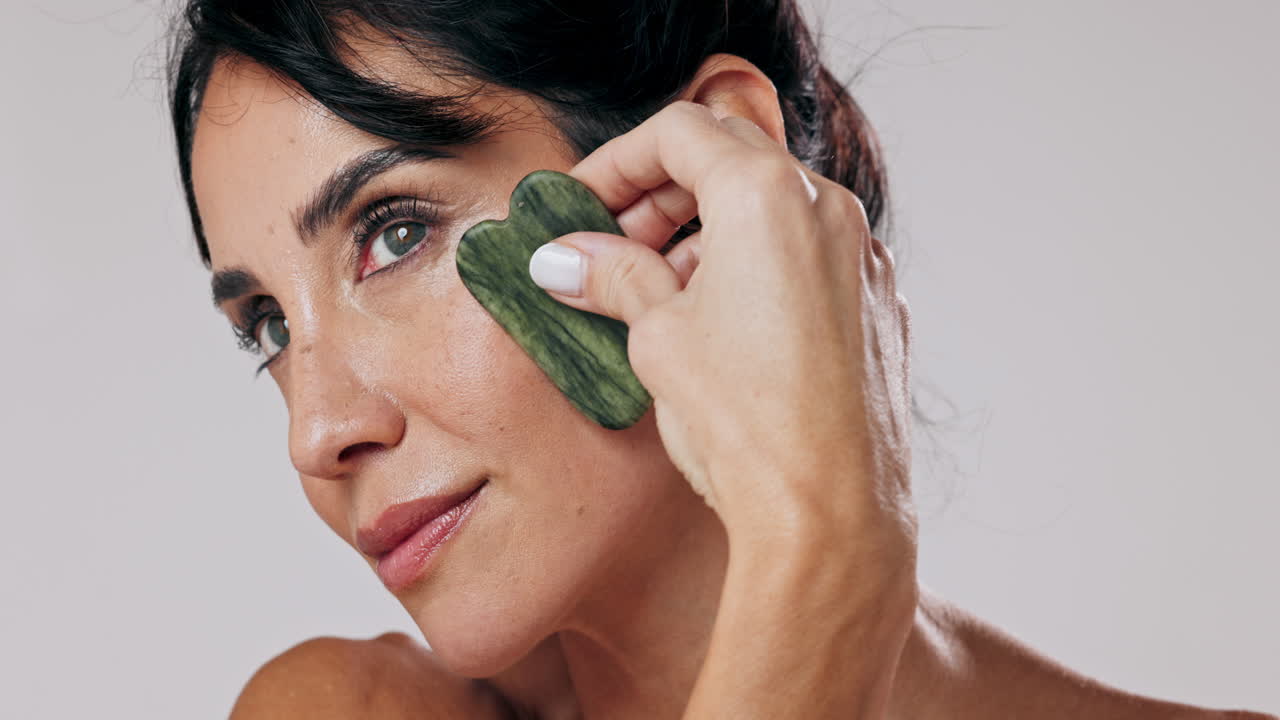 mujer recibiendo masaje facial de gua sha