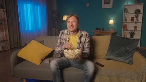 man watching a movie with popcorn
