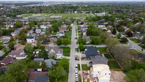 drone tilting up over milton suburban street flying towards a running track