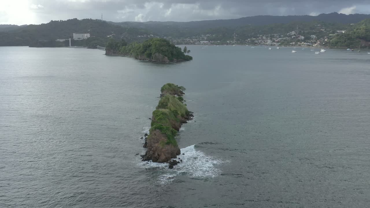 Aerial orbiting around sea rocks with Samana Bay in background, Dominican Republic