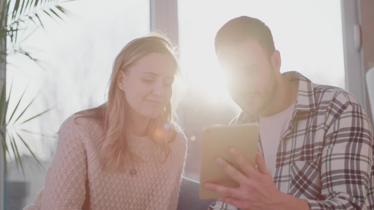 pareja discutiendo y viendo tableta