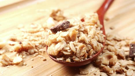 Close-up-of-roasted-oats-flakes-on-spoon-on-table-,