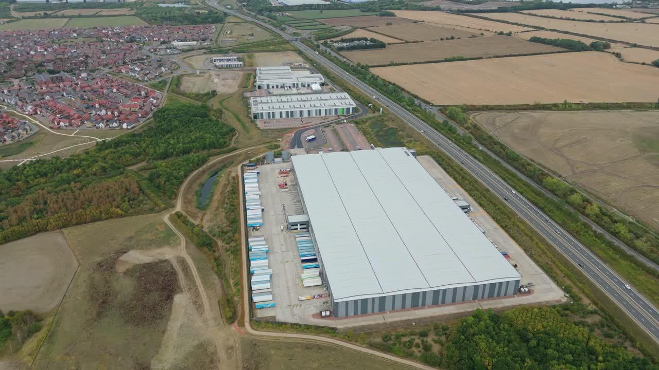 Overhead video of industrial warehouse and distribution yard in Bedford UK, showing heavy trucks and trailers in active loading operations