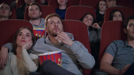una pareja enamorada abrazándose en el cine.