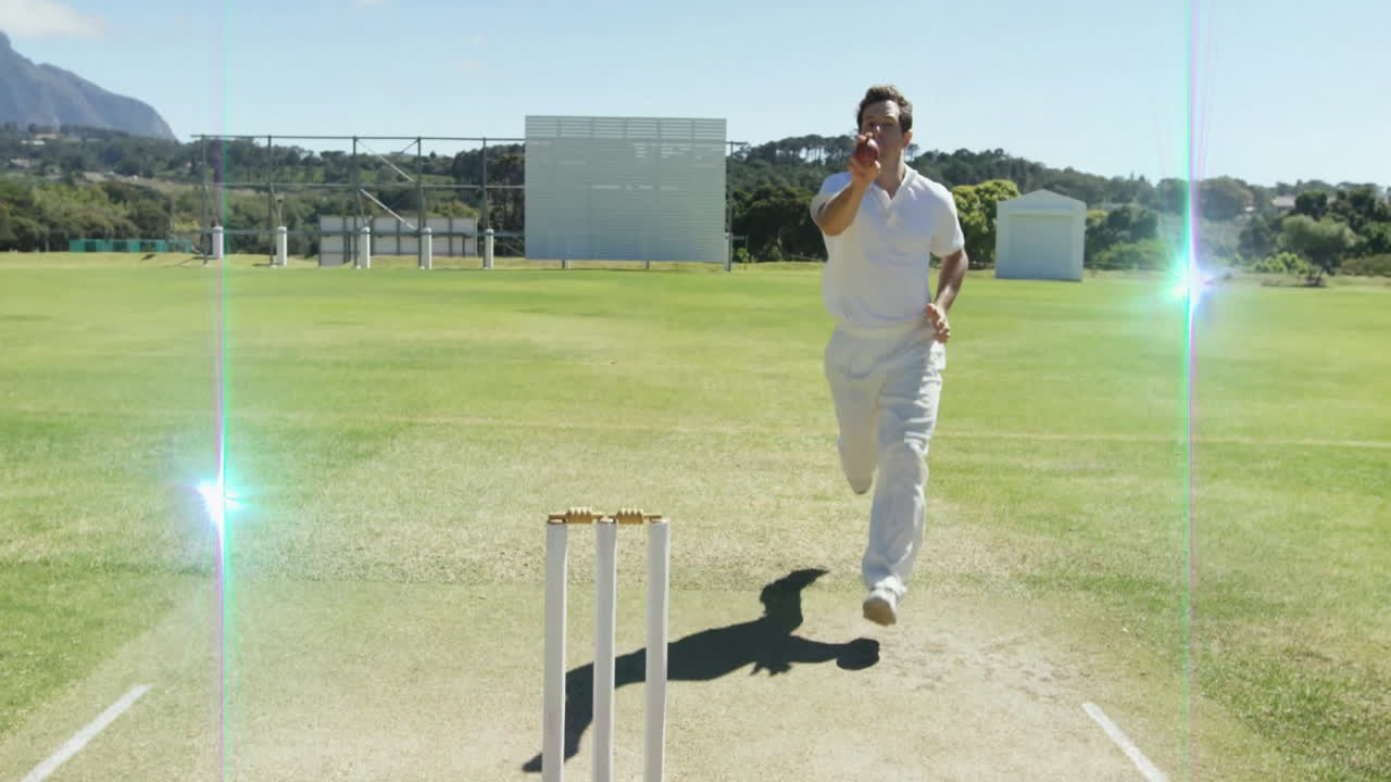 Running towards stumps, cricketer in white uniform on grassy field