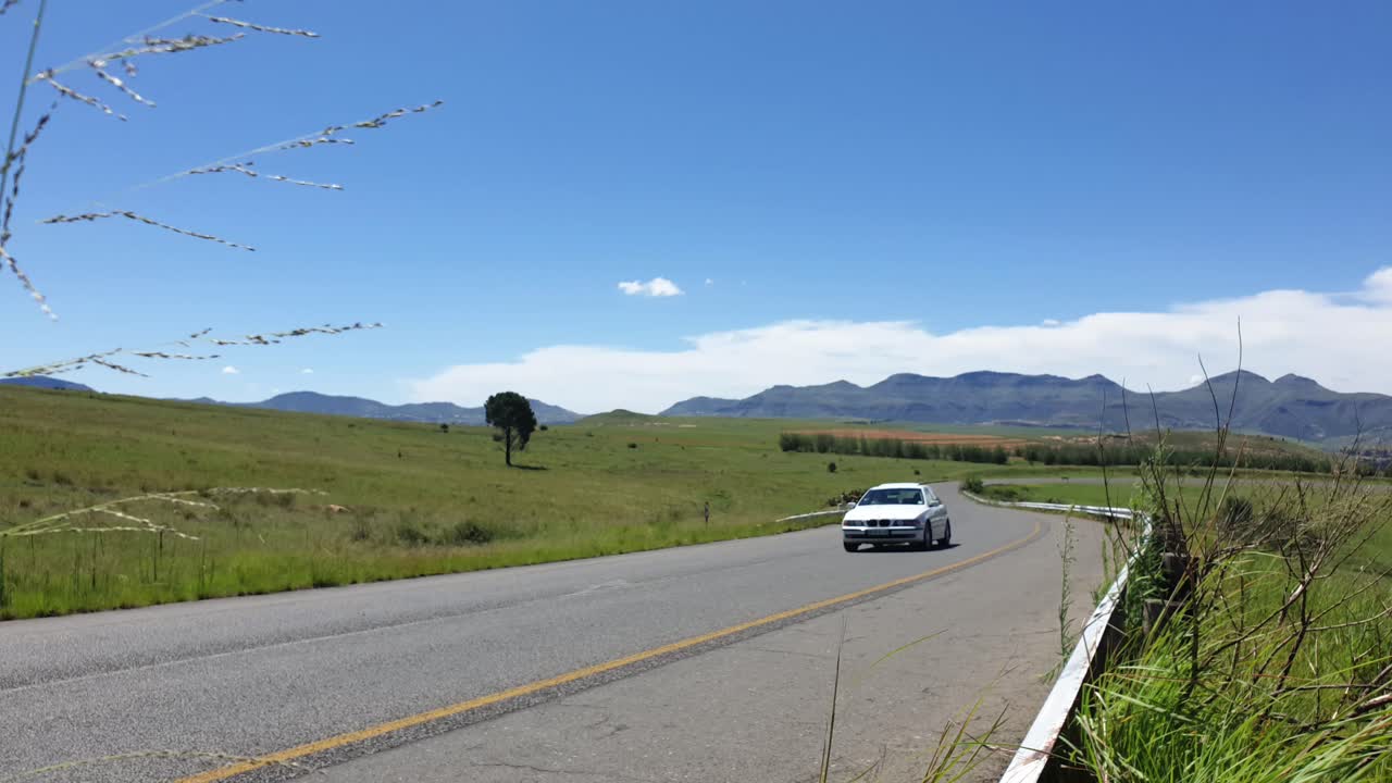 R711 road outside Clarens town in Free-state province South Africa with cars and motorbike traffic traveling past on vacation in Moluti Mountains.