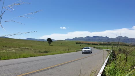 r711 road outside clarens town in free-state province south africa with cars and motorbike traffic traveling past on vacation in moluti mountains.