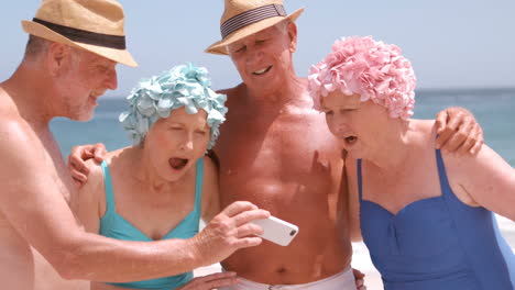 un grupo de amigos maduros están viendo un teléfono inteligente