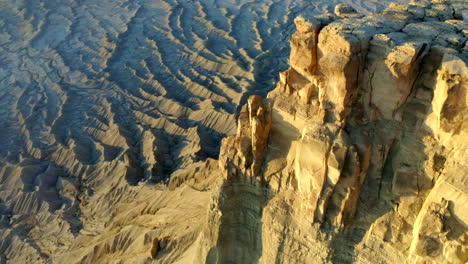 drone footage flying over factory butte with crazy rock formations, textures and moonscape at golden hour in utah