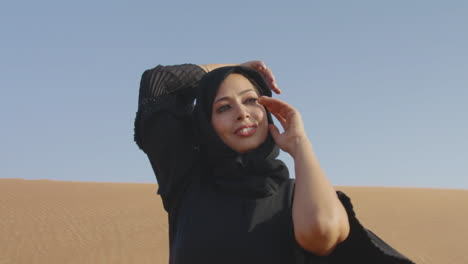 Mujer-Musulmana-Con-Vestido-Negro-Tradicional-Y-Hiyab-Posando-En-Un-Desierto-Ventoso-1
