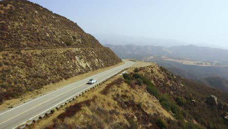 breath-taking aerial view of massive valley canyon with sedan driving along scenic road