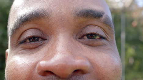 Portrait-of-happy-eyes-of-african-american-man-in-sunny-garden,-slow-motion