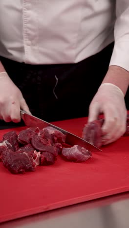 chef cutting raw meat