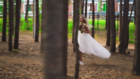 blonde bride in wedding dress and sneakers runs along forest