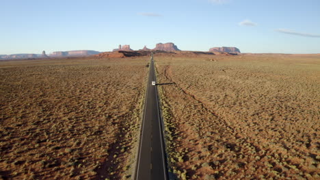 drone footage of rv, motorhome driving along iconic forest gump highway in monument valley, utah on american road trip