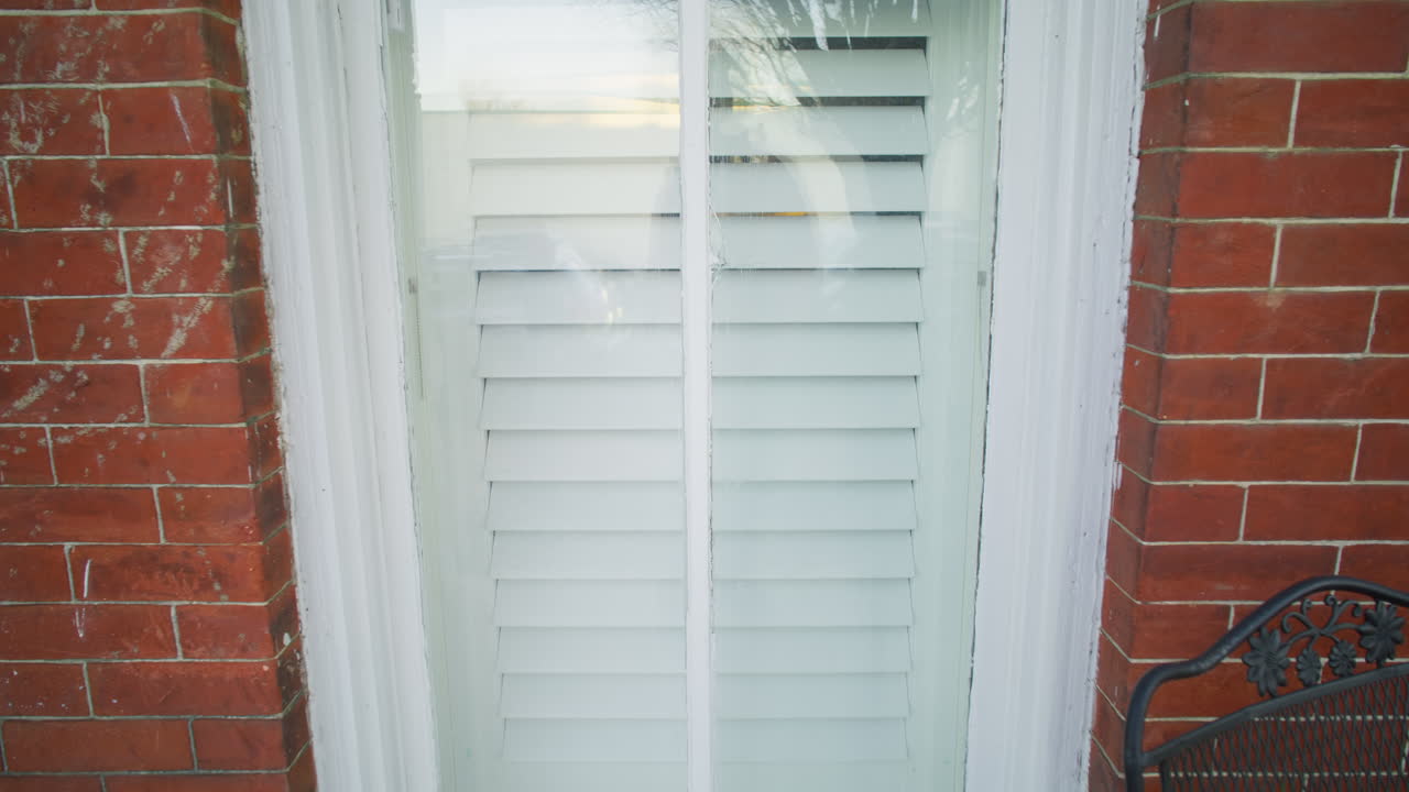 Gimbal shot of the outside of a window in a brick house