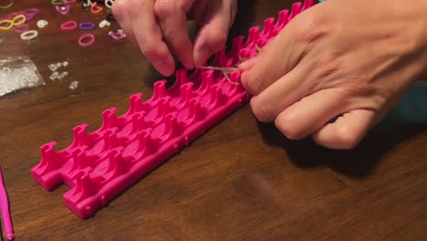 Woman-using-a-rubber-band-loom,-close-up