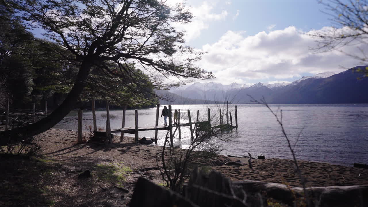Mother and daughter walking back on a rustic wooden pier, Lago Traful, Neuquén, Argentina