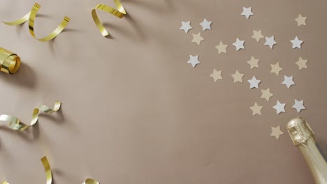 Champagne-bottle-with-decorations-and-stars-on-green-background-at-new-year's-eve