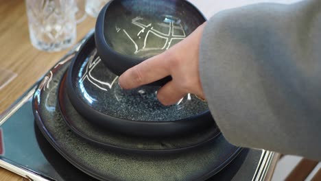 mujer preparando una mesa con hermosos platos