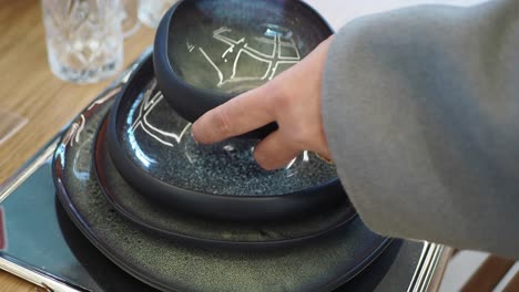 woman setting a table with beautiful plates