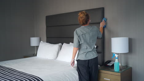 The-maid-efficiently-goes-about-her-tasks,-tidying-up-the-hotel-room-with-precision-and-care,-by-wiping-and-cleaning-everything-in-a-hotel-room