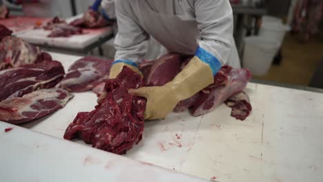butcher cutting beef in a meat processing plant