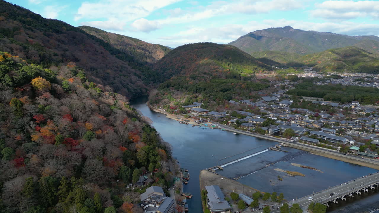 Drone diving toward the Katsura river, partly sunny, autumn day in Kyoto, Japan