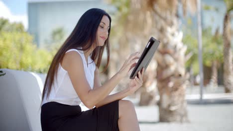 Lächelnde-Junge-Frau-Mit-Ihrem-Tablet-Im-Freien