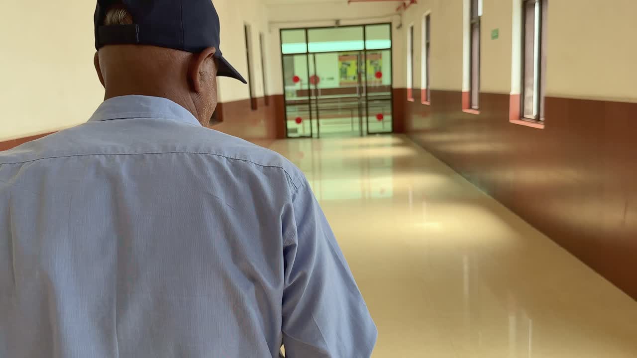 Security Guard Walking Down a Long Hallway