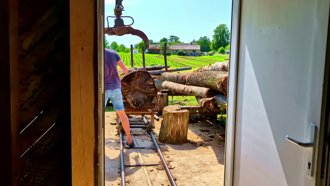 Man working with logs at a sawmill