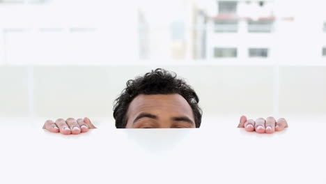 anxious man peering over desk