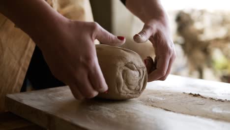 Unrecognizable-woman-cutting-the-clay-before-begin-sculpting-close-up-in-workshop.-Making-ceramic-products.-Artistic-creative.-Sculptor-sculpts-pots-products.-Master-crock.-Potter's-work-close-up