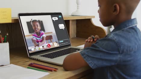 Niño-Afroamericano-Sosteniendo-Un-Lápiz-Haciendo-Una-Videollamada-En-Una-Computadora-Portátil-En-Casa