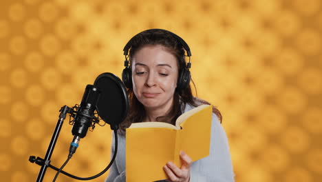 narrador feliz con auriculares leyendo en voz alta del libro al micrófono