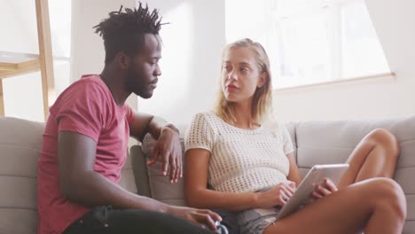 pareja discutiendo entre sí mientras usan una tableta digital