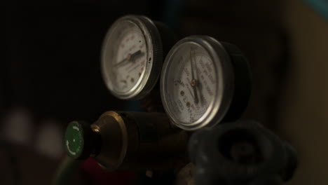 la presión se ajusta a medida que los medidores muestran valores en la máquina de soldadura de gas en un taller