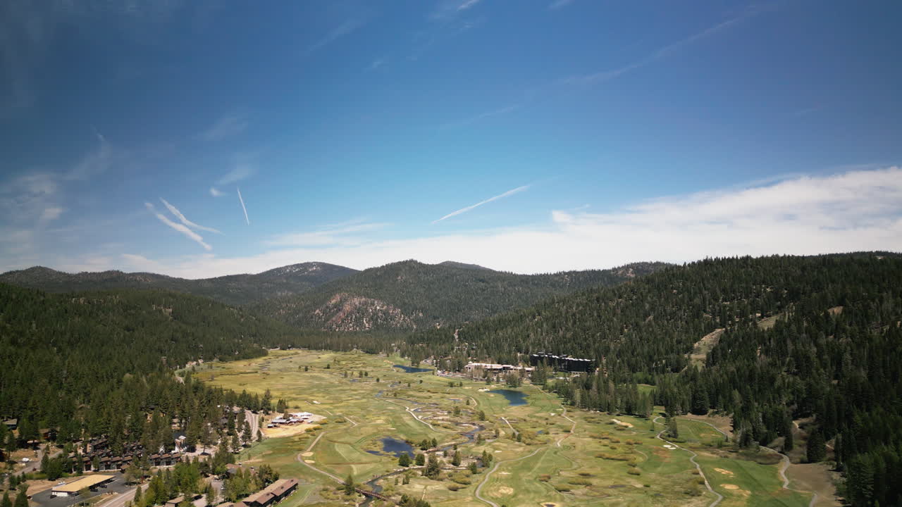 Stunning aerial drone view of Olympic Valley in Lake Tahoe region. Mountain landscape showcases ski resort and alpine scenery. Perfect for California travel and winter sports