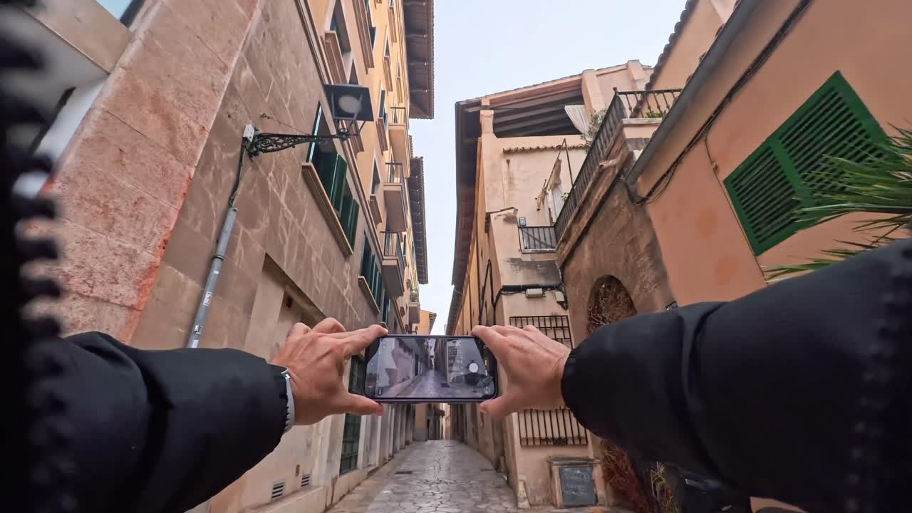 POV di un turista che usa lo smartphone per riprendere una strada di Palma di Maiorca