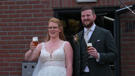 bride and groom toast their guests at wedding, frontal outdoors shot