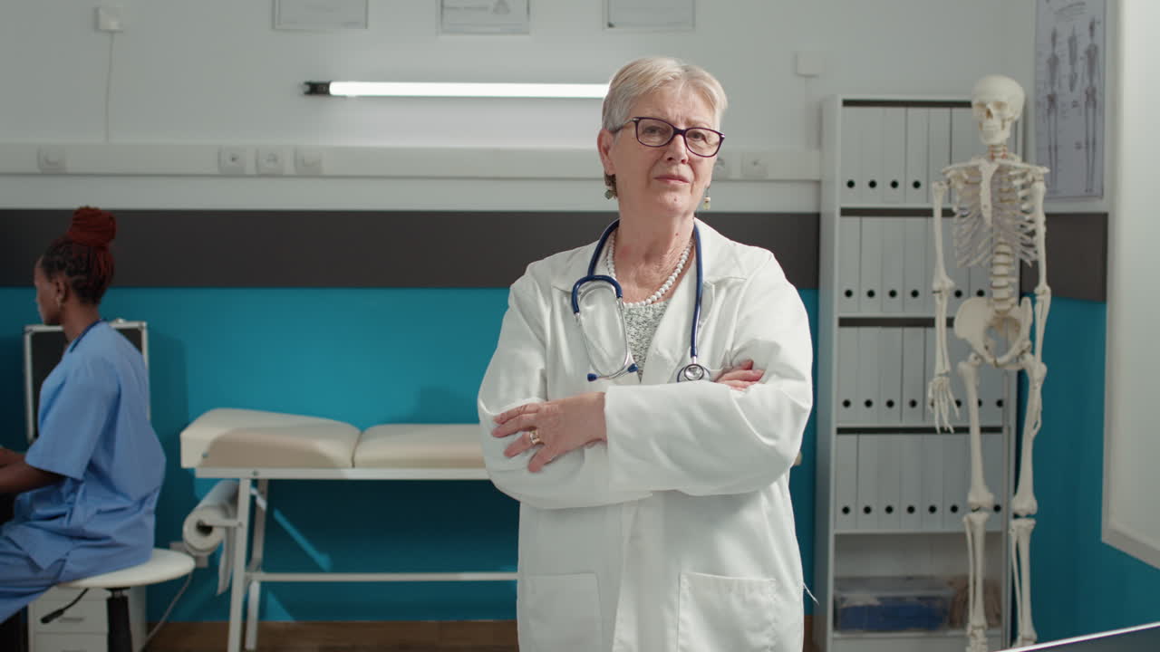 Portrait of senior doctor standing with arms crossed in cabinet