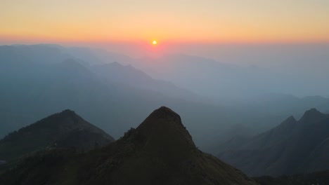 aerial drone shot of kolukkumalai range in the early morning light, shrouded in mist