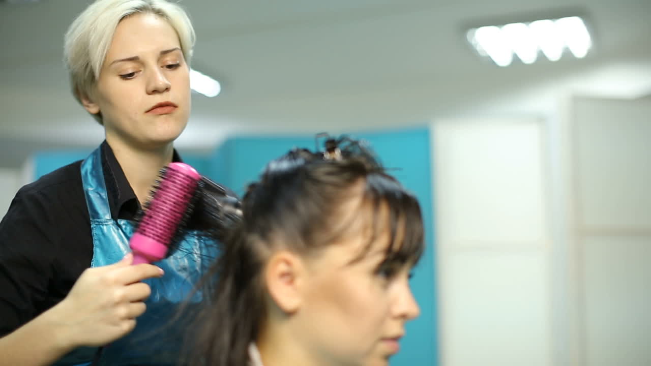 Cutting hair at salon. Young woman having her hair dyed by beautician at parlor